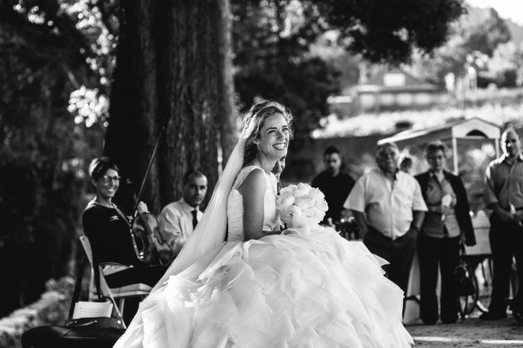 Black and white photograph of a bride laughing with her guests