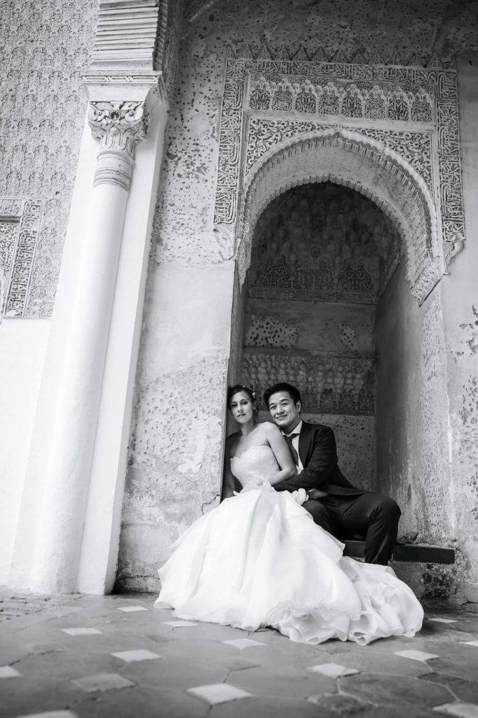 Black and white portrait of a couple in a Nasrid archway in Granada