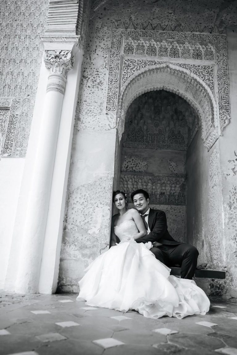 Black and white portrait of a couple in a Nasrid archway in Granada