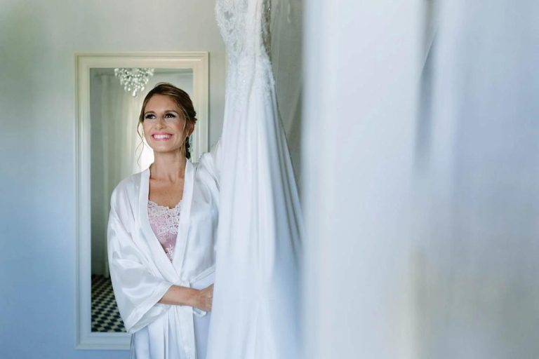 Bride getting ready, smiling softly by the window