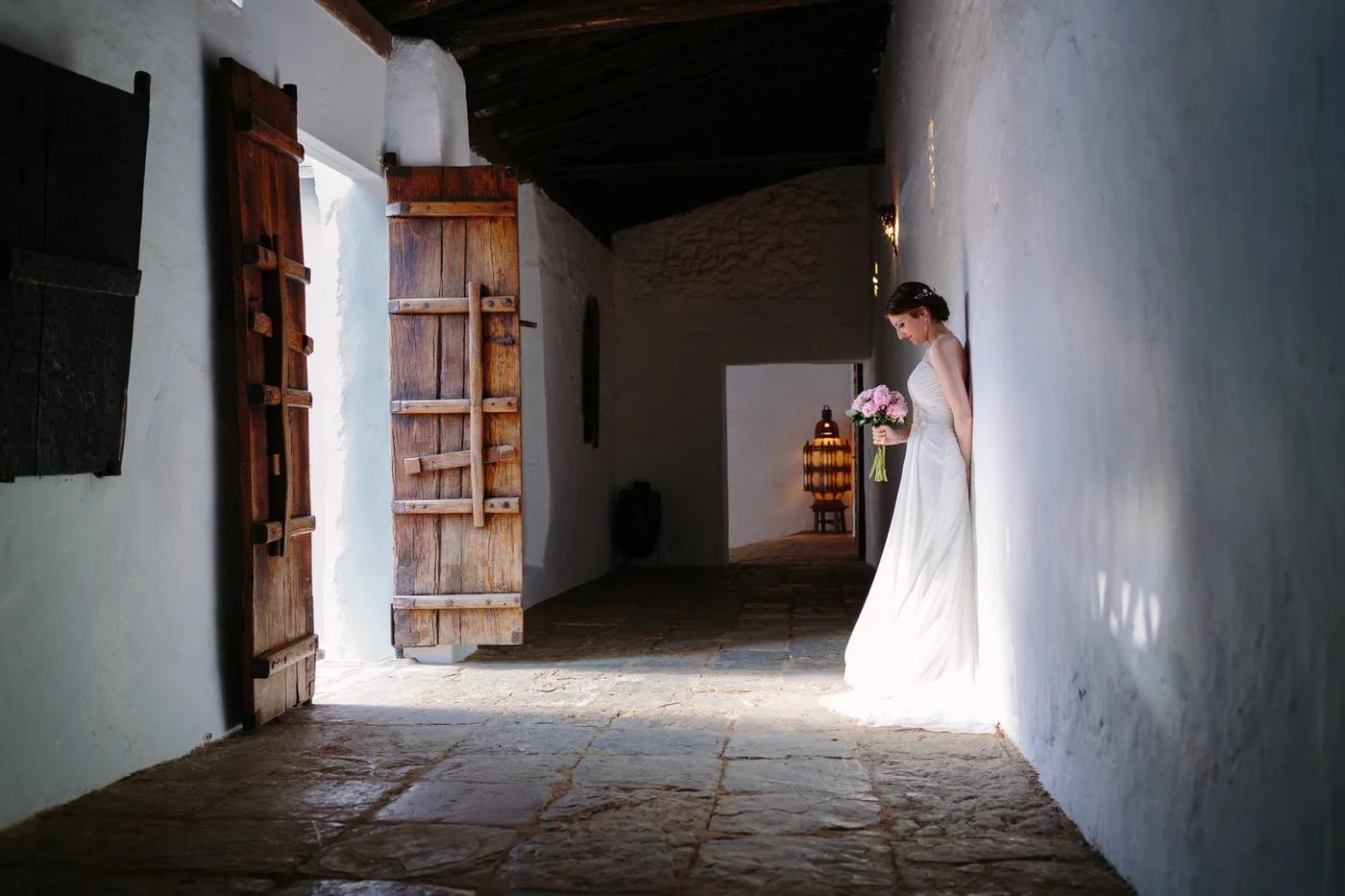 Bride walking through a whitewashed corridor in Sevilla