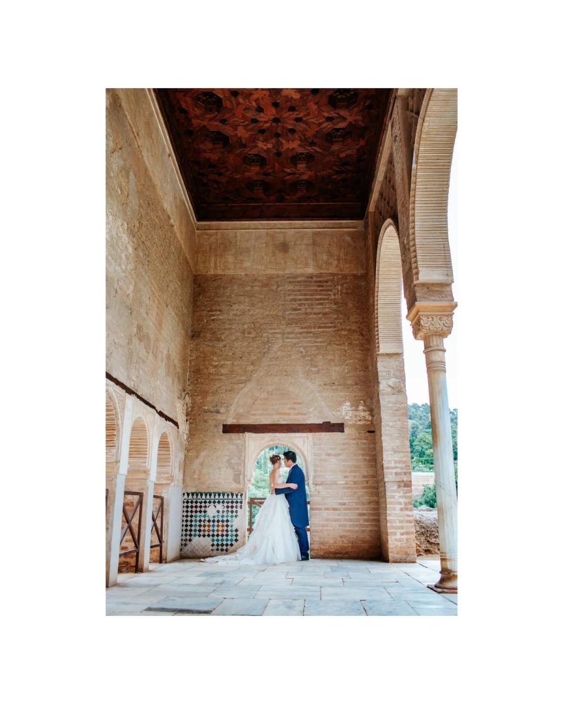 Couple framed by the arcades of the Alhambra in Granada