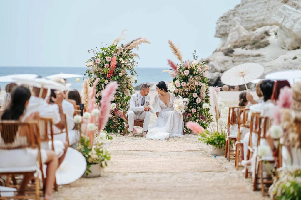 Guests seated along the aisle at the beach ceremony in Cabo de Gata, with pampas grass and white parasols