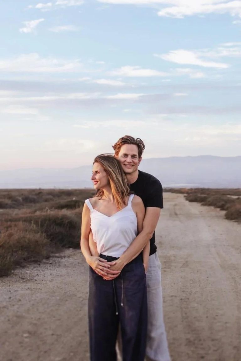 Joost and Marie, wedding photographers, embracing on a country road at sunset