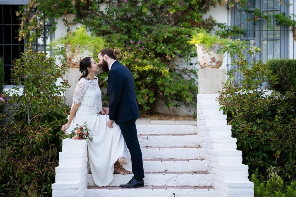 Pauline and Raúl kissing on white steps at Casa Grande de Zujaira, Granada